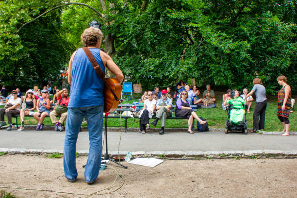 NYC, NY USA Aug 10, 2013: A very appealing and talented performer, locally known as “That Guitar Man” entertains a crowd of Upper-West-Siders in Central Park adjacent to the Boat Lake.