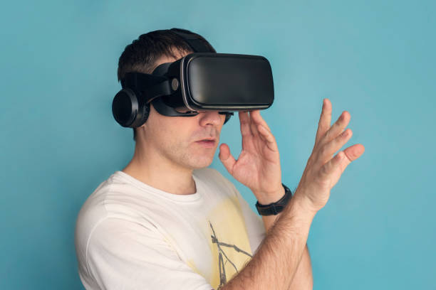 istock Happy man play vr eyeglasses on blue background 2169658274