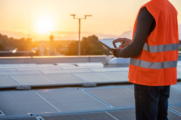 istock Mid Adult Caucasian Engineer Adjusts Solar Panels on Rooftop 2169658960