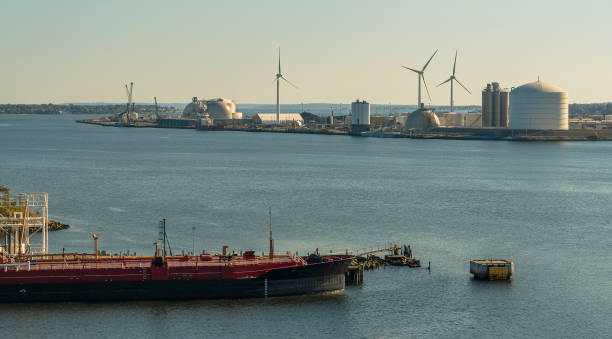 Strasbourg, France - 11 April 2022: Fuel storage tanks and a tanker barge at the entrance to the Port of Strasbourg in early monring light