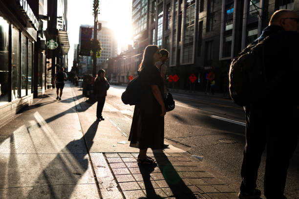Toronto, Ontario, Canada - August 23, 2024:  Pedestrians navigate through downtown Toronto in the early morning hours.