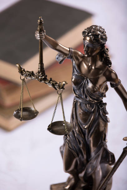 istock Lady Justice with books in the background on white marble 2169667329