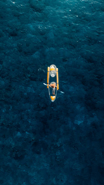 istock Vertical Screen: Woman on transparent kayak in tropical blue ocean. Drone view 2169676830
