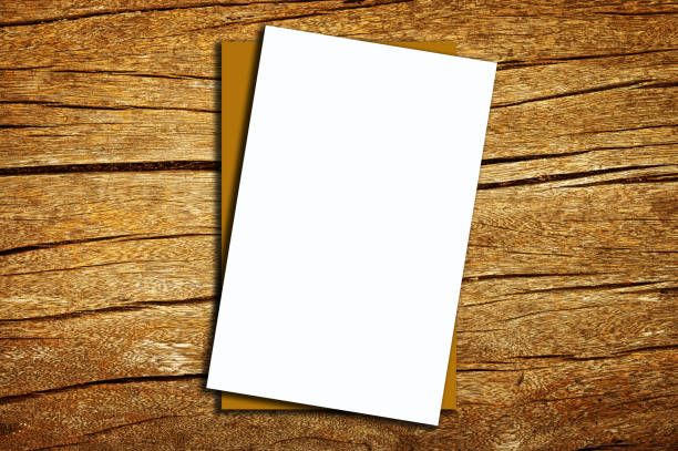 Blank paper card on old weathered wooden table background