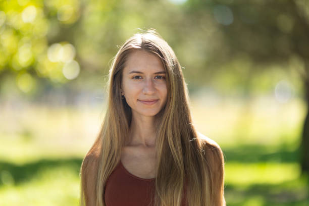 istock Young woman smiling outdoors in a park 2169681980