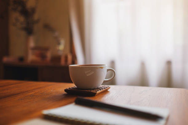 istock A coffee cup with notebook and a pen on wooden table 2169682154
