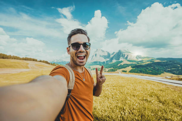 istock Happy man taking selfie with smart mobile phone over mountains background - Cheerful hiker having fun climbing outside - Hiking, travel and technology life style concept 2169686906