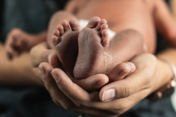 istock Anonymous mother holding baby feet 2169691796