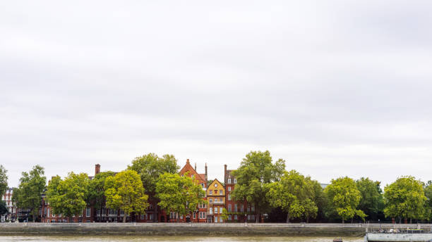 Somerset House on Thames River in City of Westminster, London. Commercial signs are visible on the barges.