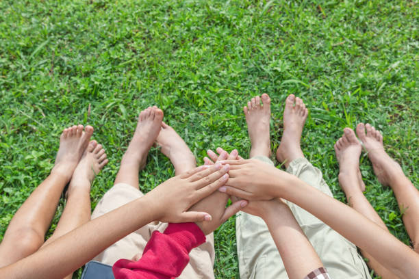 Environment conservation concept. Young children hands stack together on green nature background for sustainable development goal