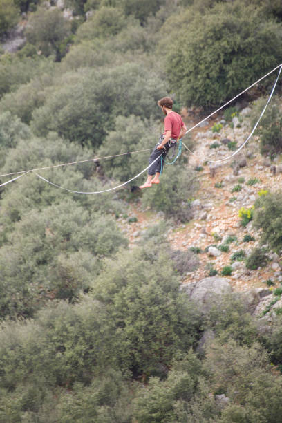 istock A tightrope walker walks along a cable stretched over a canyon. 2169696405