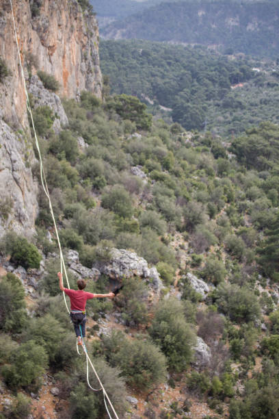 istock A tightrope walker walks along a cable stretched over a canyon. 2169696450