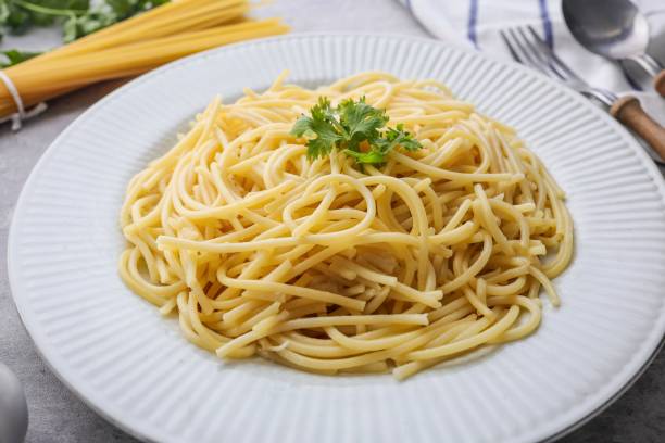 istock Boiled spaghetti , cooked spaghetti , boiled spaghetti in a white ceramic plate on grey cement background 2169702514