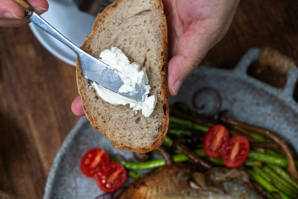 istock to spread cream cheese on slice of wholegrain bread 2169703629
