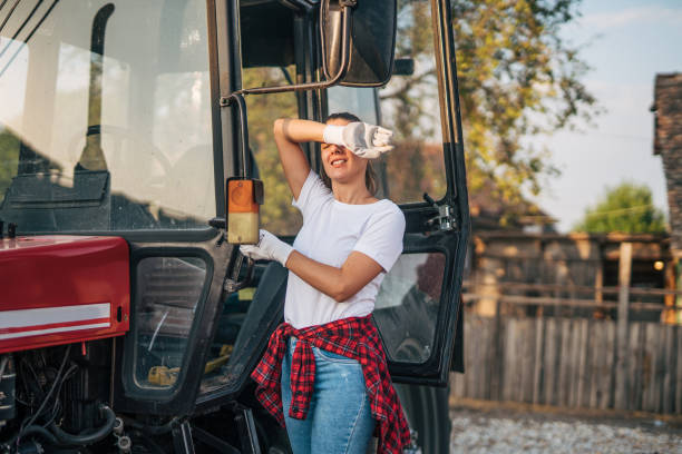 Black woman farmer driving tractor. Farmer woman smiling sitting on small farm tractor, enjoy the work concept.