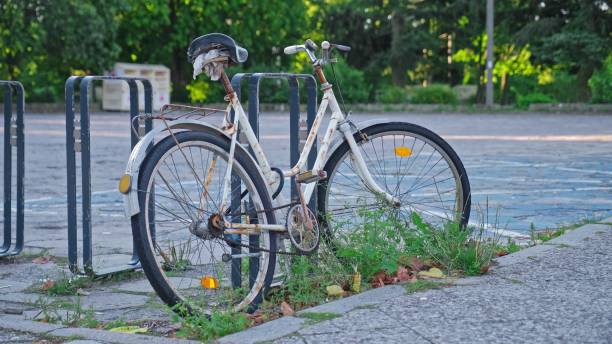 istock Abandoned Old Rusty Bicycle Secured with Lock Cable by City Bike Stand 2169705183