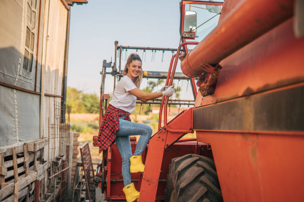 istock Young cheerful woman farmer  is Getting into the combine 2169705532