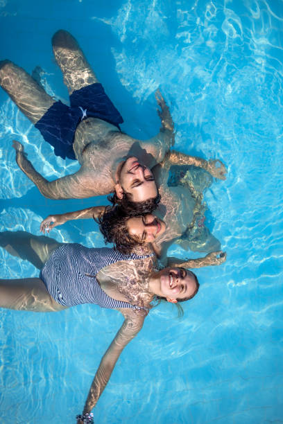 istock Directly above three friends in the pool on sunny day 2169710198