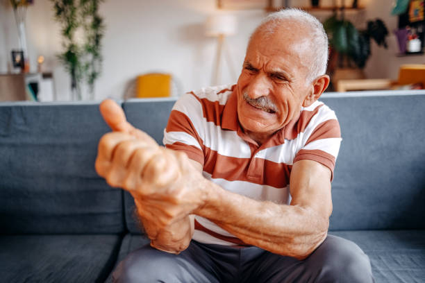 istock Old man feeling pain at home in living room while sitting on sofa 2169711833