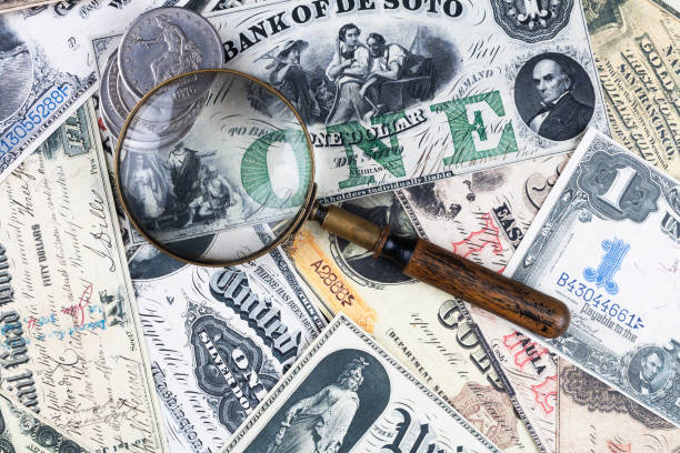 istock Old west US banknotes and silver certificates with silver dollar coins and magnifying glass 2169717808