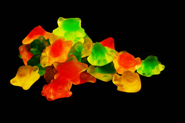 Heap of colorful gummy candies isolated on black background.