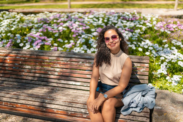 istock Woman sitting on bench looking at camera 2169730437