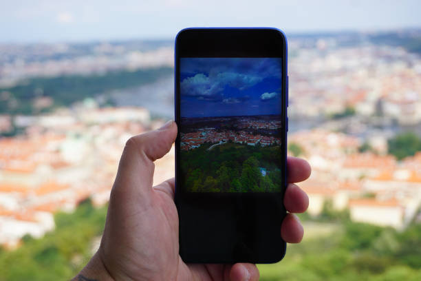 istock Cropped hand holding mobile phone while photographing cityscape 2169732770