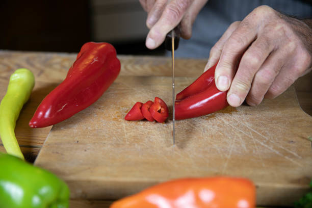 istock Senior Hand Preparing a Red Bell Pepper in a Cozy Kitchen 2169733915