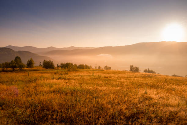 istock Stunning Sunrise Over an Open Field with a Breathtaking Mountain Backdrop in View 2169736702