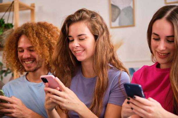 istock Group teenagers holding mobile phones watching video or chatting at shared flat. 2169741119
