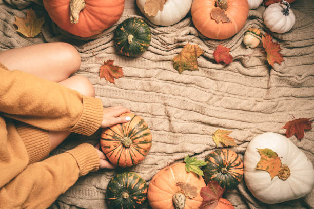 istock woman sitting between pumpkins 2169744760