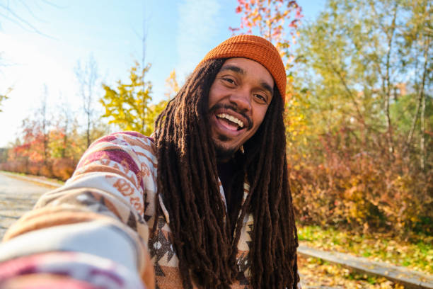 istock African man with dreadlocks smiling and taking a selfie in fall. 2169744783
