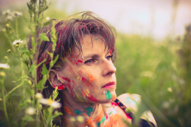 surrounded by wildflowers, with bright shades of color on her clothes and hair.