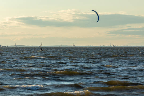Sandy Hook, New Jersey - August 21, 2024: Kiteboarders take to the water as the sun sets over Sandy Hook on a gorgeous summer's night