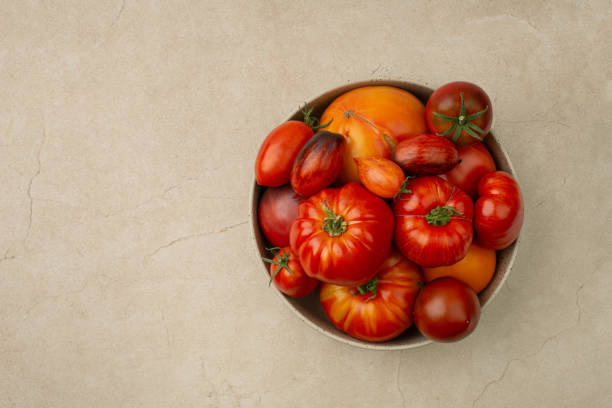 Red ripe organic tomatoes in a plate on the table