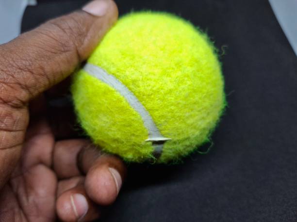 A tennis ball is a pressurized, rubber sphere covered in bright, felt fabric. It’s designed for high bounce and durability, used in tennis matches to be hit back and forth.