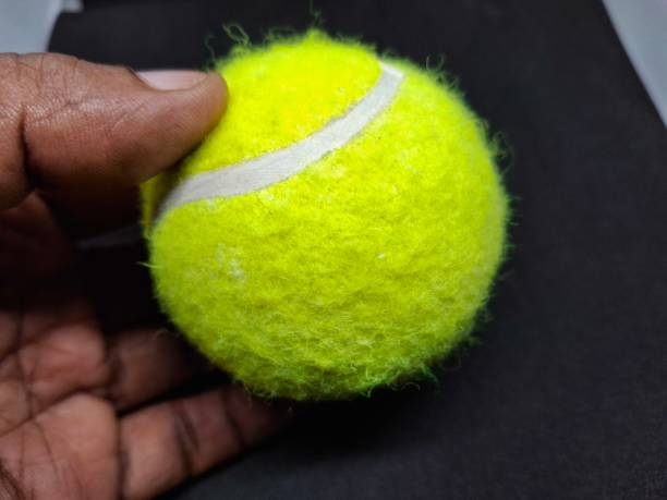 istock A tennis ball is a pressurized, rubber sphere covered in bright, felt fabric. It’s designed for high bounce and durability, used in tennis matches to be hit back and forth. 2169757890