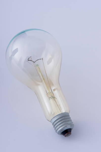 istock An old glass light bulb with a tungsten filament white background. Metal base. 2169758955