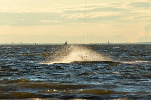 Sandy Hook, New Jersey - August 21, 2024: Kiteboarders take to the water as the sun sets over Sandy Hook on a gorgeous summer's night