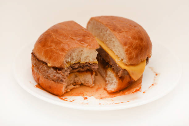 Cheeseburger on a white background. Meat burger cut into slices.