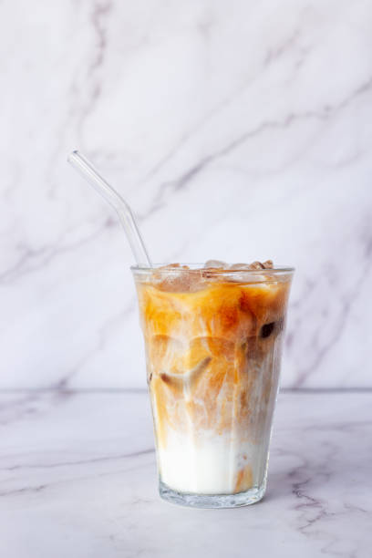 istock a glass of iced latte coffee on white marble table background. 2169763089