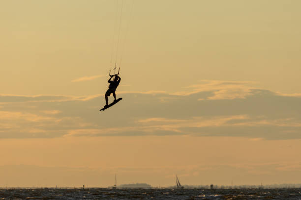 Sandy Hook, New Jersey - August 21, 2024: Kiteboarders take to the water as the sun sets over Sandy Hook on a gorgeous summer's night