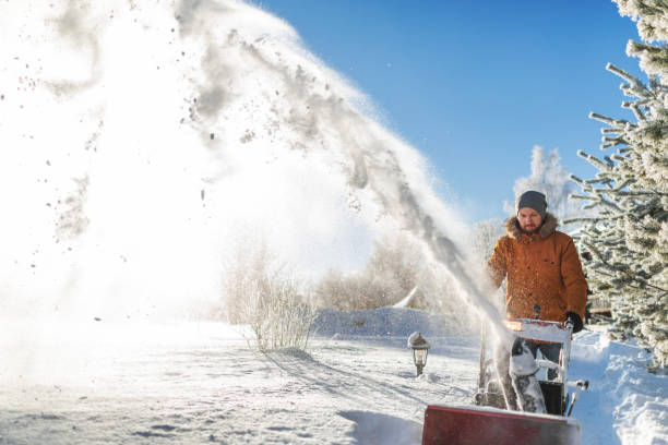 Mid adult man using snowblower after heavy snowfall at backyard