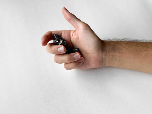 istock Hand holding black polyhedral dice for tabletop gaming on white background 2169768979