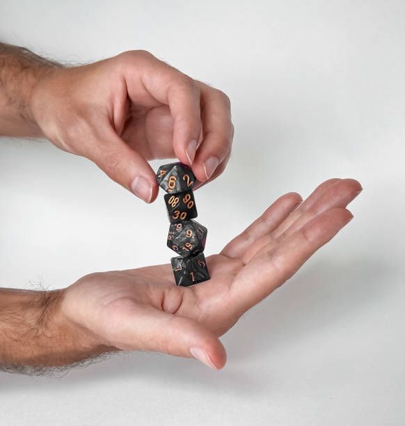Hands holding and balancing polyhedral dice set for tabletop gaming