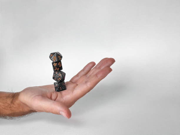 istock Hand balancing stacked dice: precision and skill in tabletop gaming 2169768995