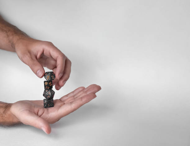 istock Hands rolling unique polyhedral dice in mid-air against a minimalistic background 2169769000
