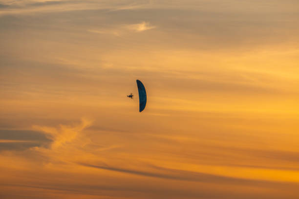 motor glider flying in the sky during sunset.