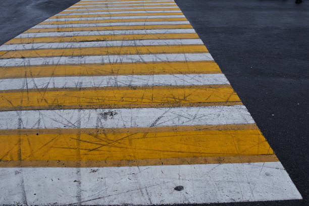 pedestrian crossing, white and yellow stripes on black asphalt, road markings. pedestrian crossing on the road to ensure safety when pedestrians cross the street.