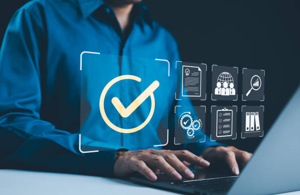 istock Digital quality control and certification concept. Businessman working on a laptop with icons quality control, certificate, and assurance. Checkmark symbol, success verification, standard compliance, 2169789601